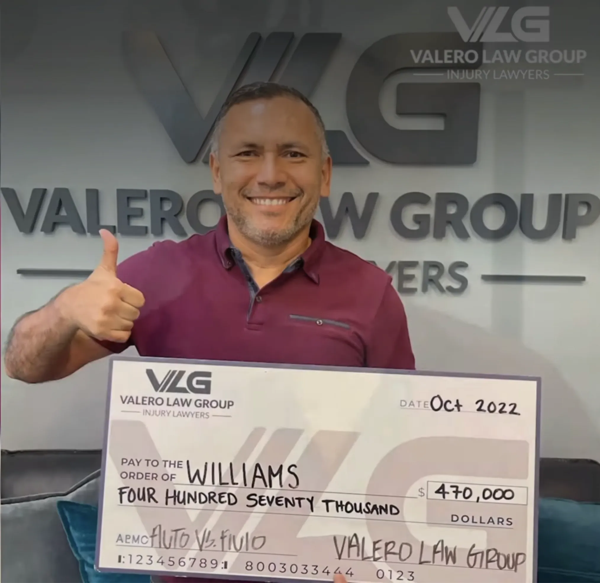 Client with a settlement check from Valero Law Group